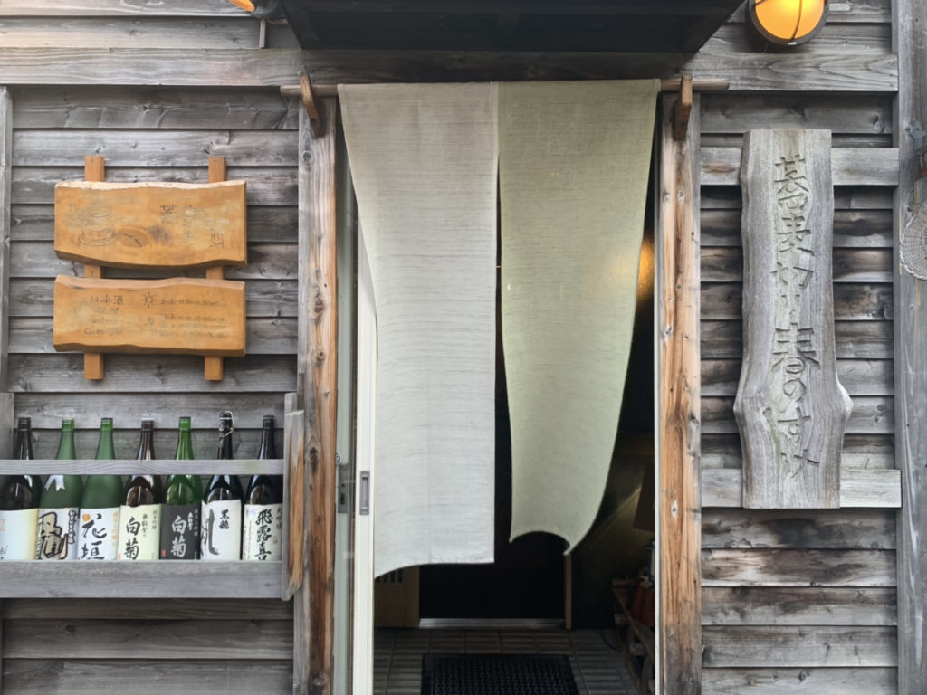 のれんと手彫りの看板がある蕎麦店の入口（蕎麦切り 春のすけ・取材当時）